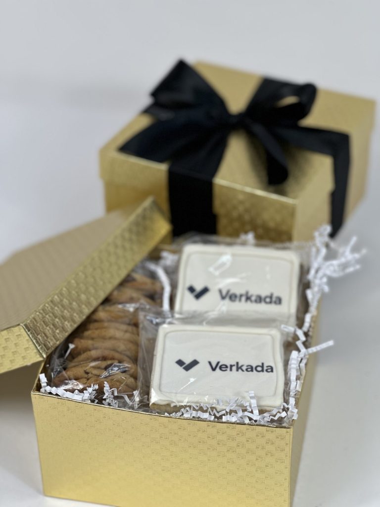 Logo-printed chocolates presented in a gold gift box with a black ribbon