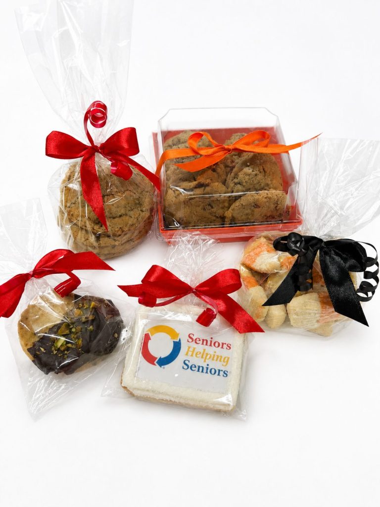 A branded logo cookie alongside ribbon-tied cookie gift packs
