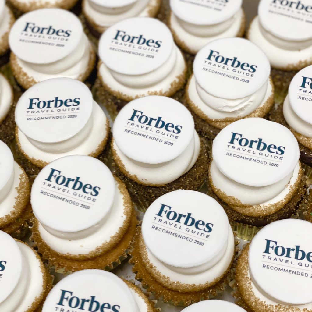 Cupcakes topped with edible-image discs carrying the Forbes Travel Guide logo