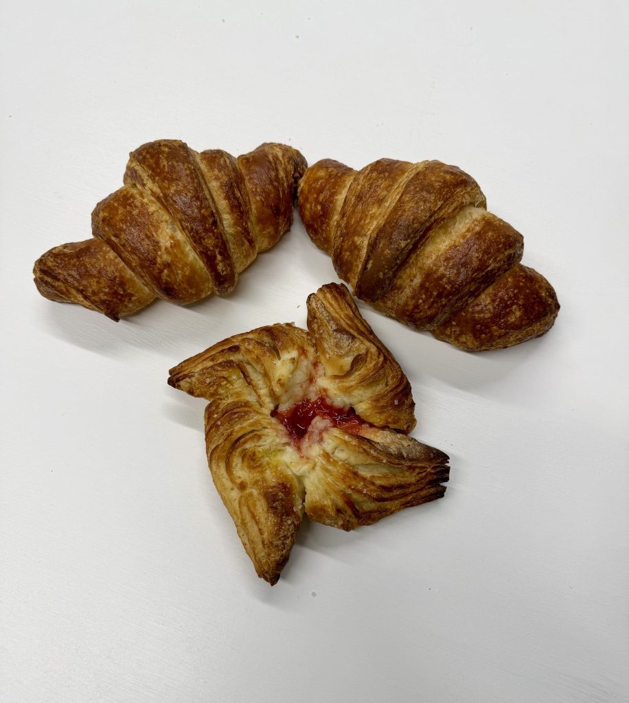 Freshly baked croissants and a fruit-filled danish pastry