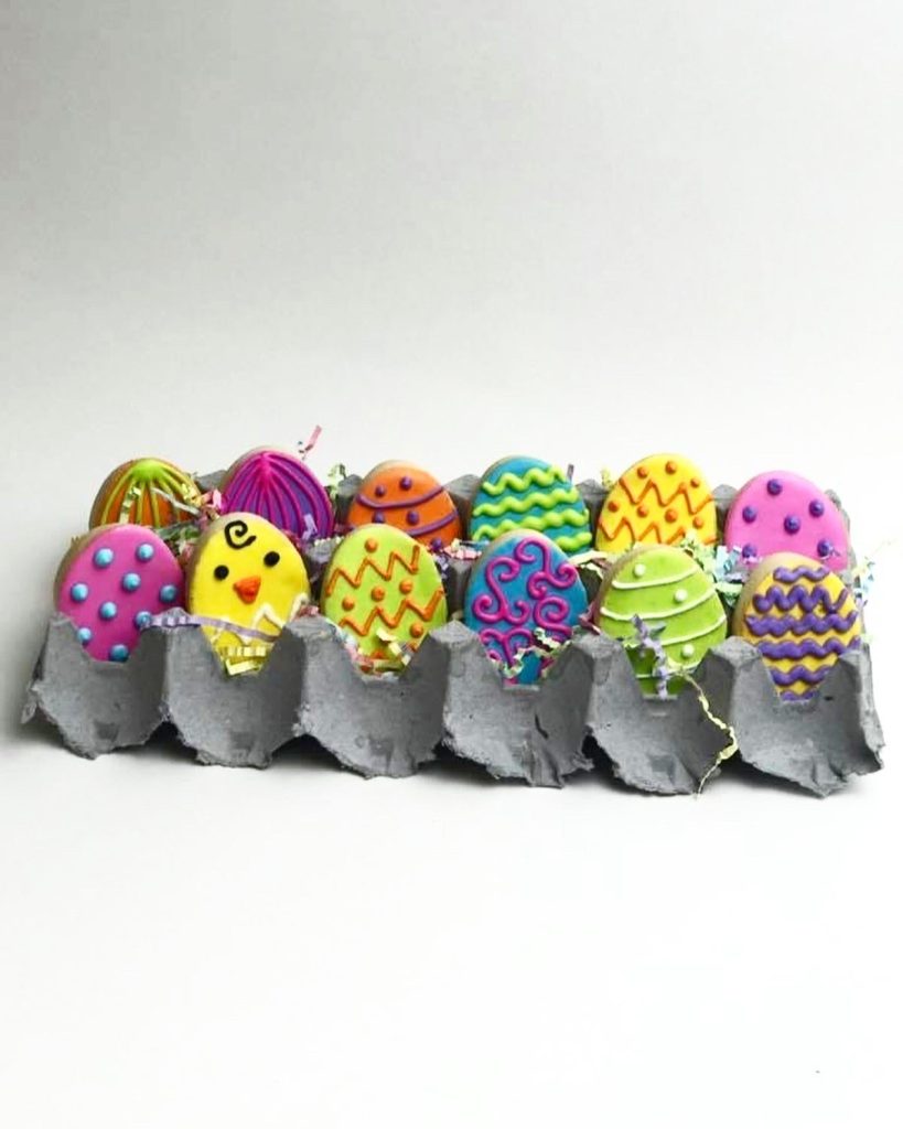 Brightly decorated cake pops presented in an egg carton