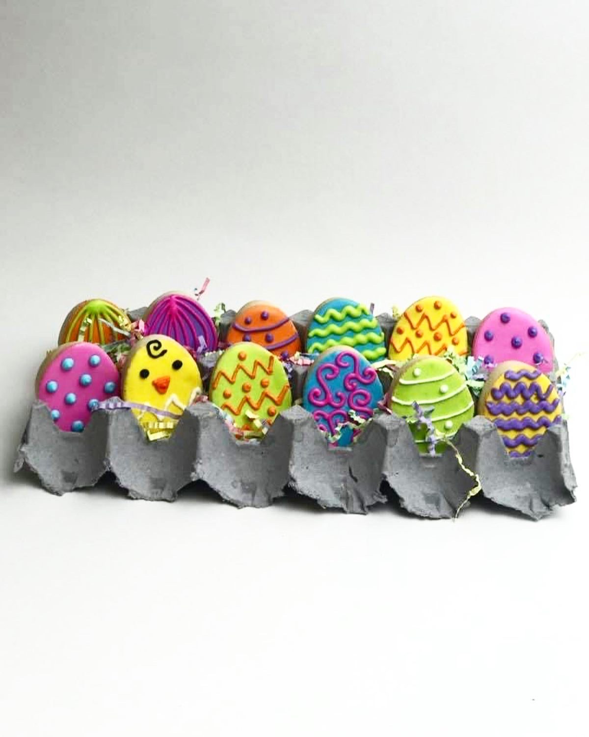 Brightly decorated cake pops presented in an egg carton