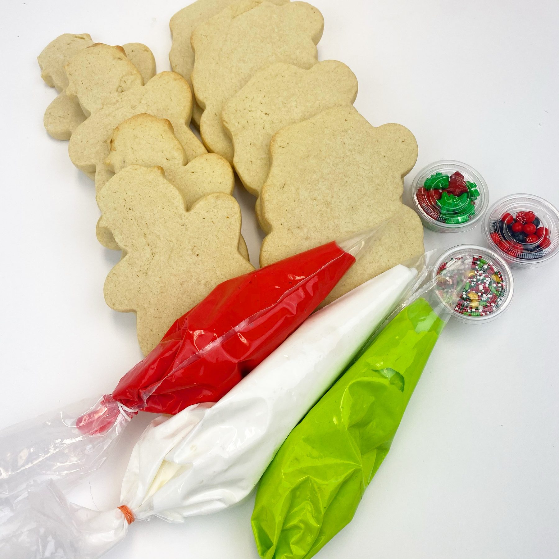 A cookie decorating kit with plain cookies, piping bags of icing and sprinkles
