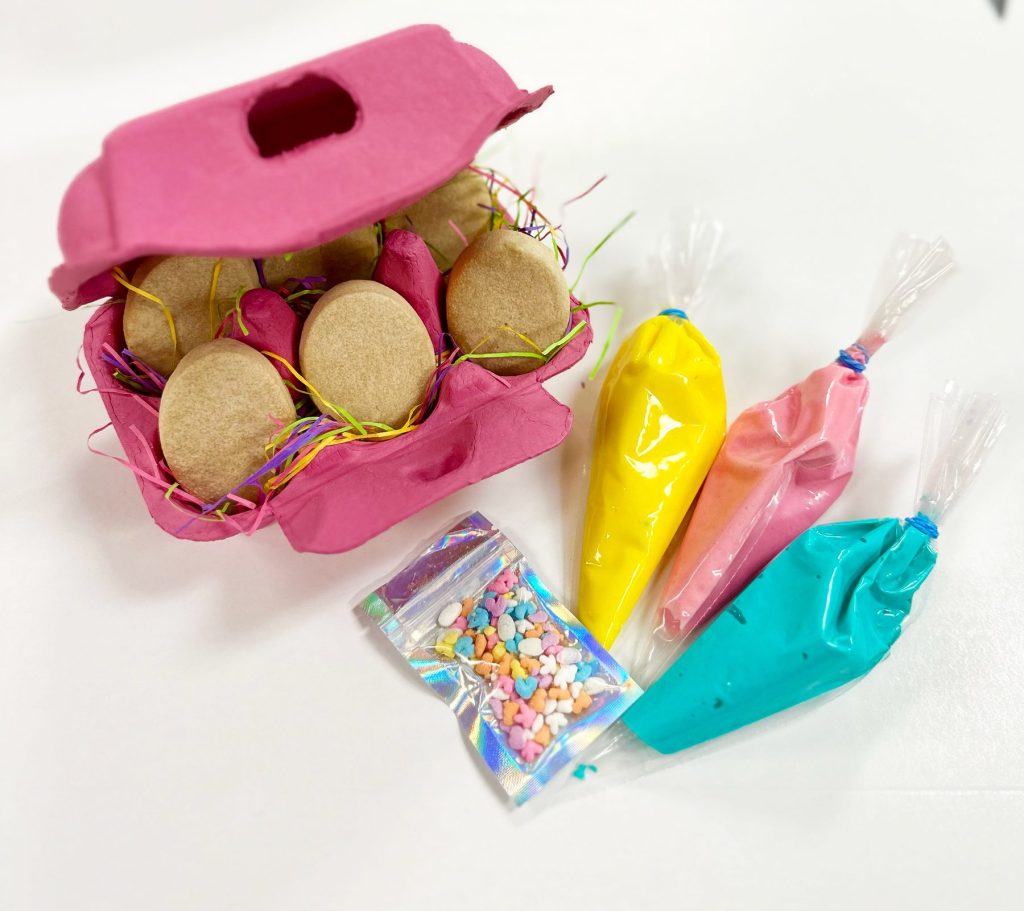 A decorating kit packed in an egg carton with icing bags and sprinkles
