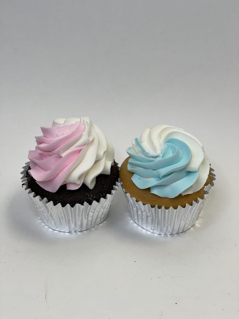 Two cupcakes swirled with pink and blue buttercream