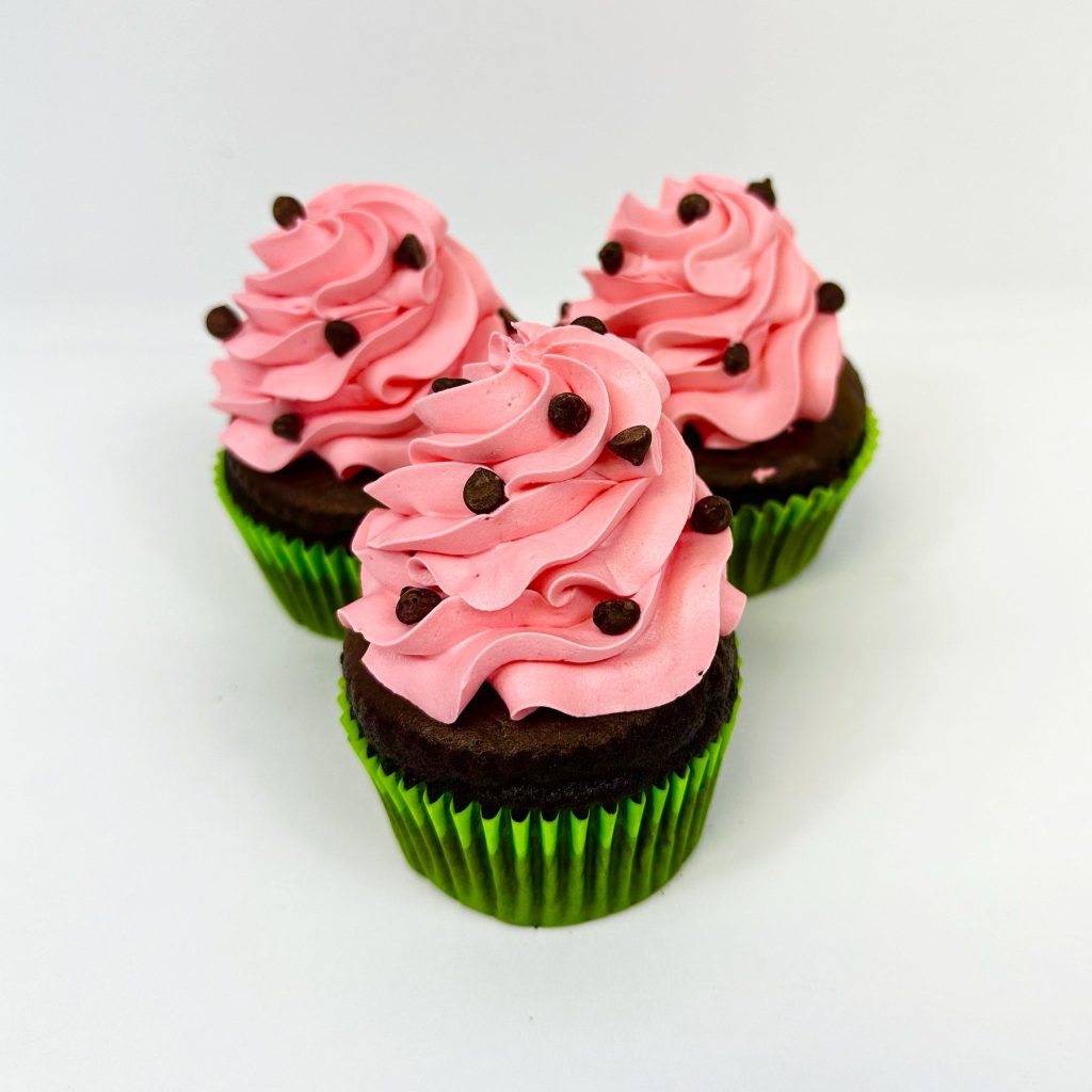 Chocolate cupcakes topped with pink buttercream and chocolate chips