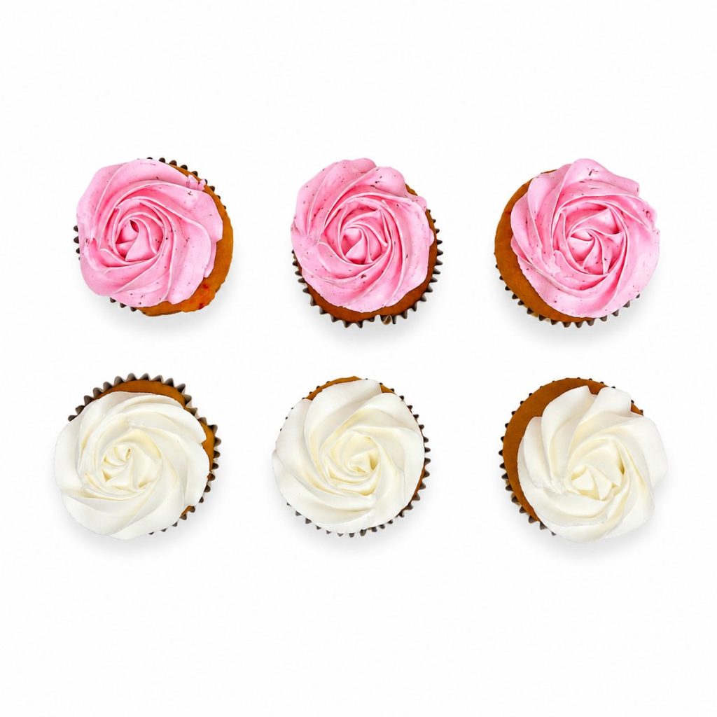 Six cupcakes piped with pink and white buttercream roses