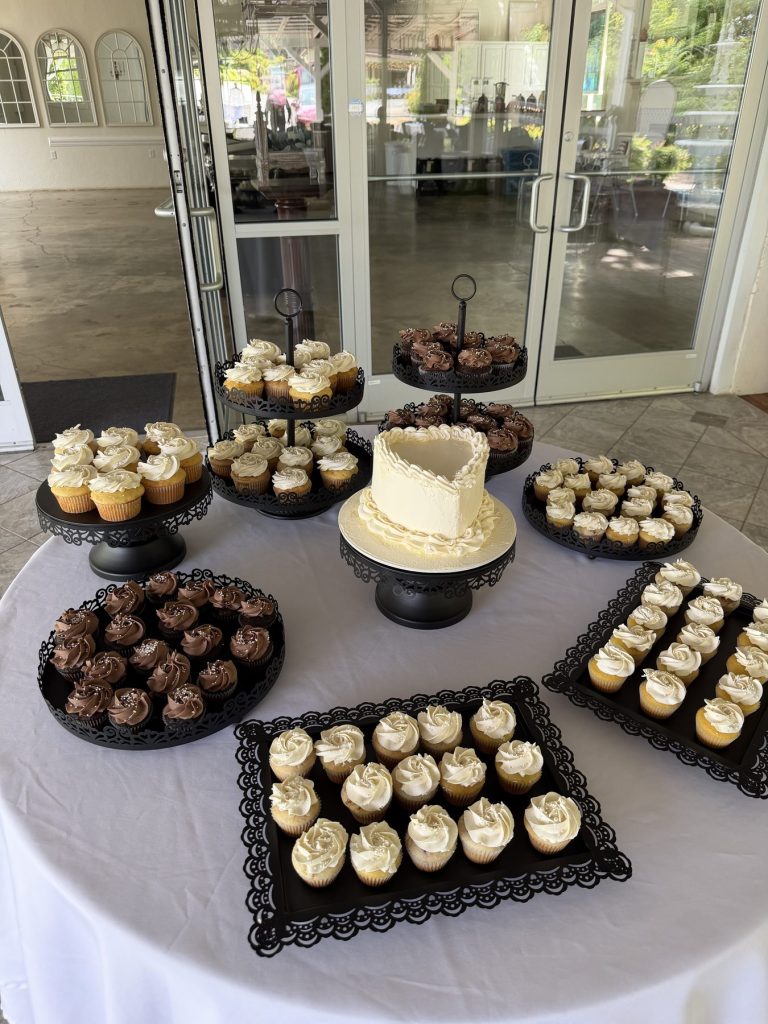 A styled event dessert table with cupcakes, truffles and petit fours