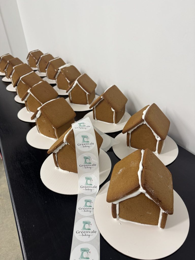 Rows of individually plated gingerbread houses prepared for an event