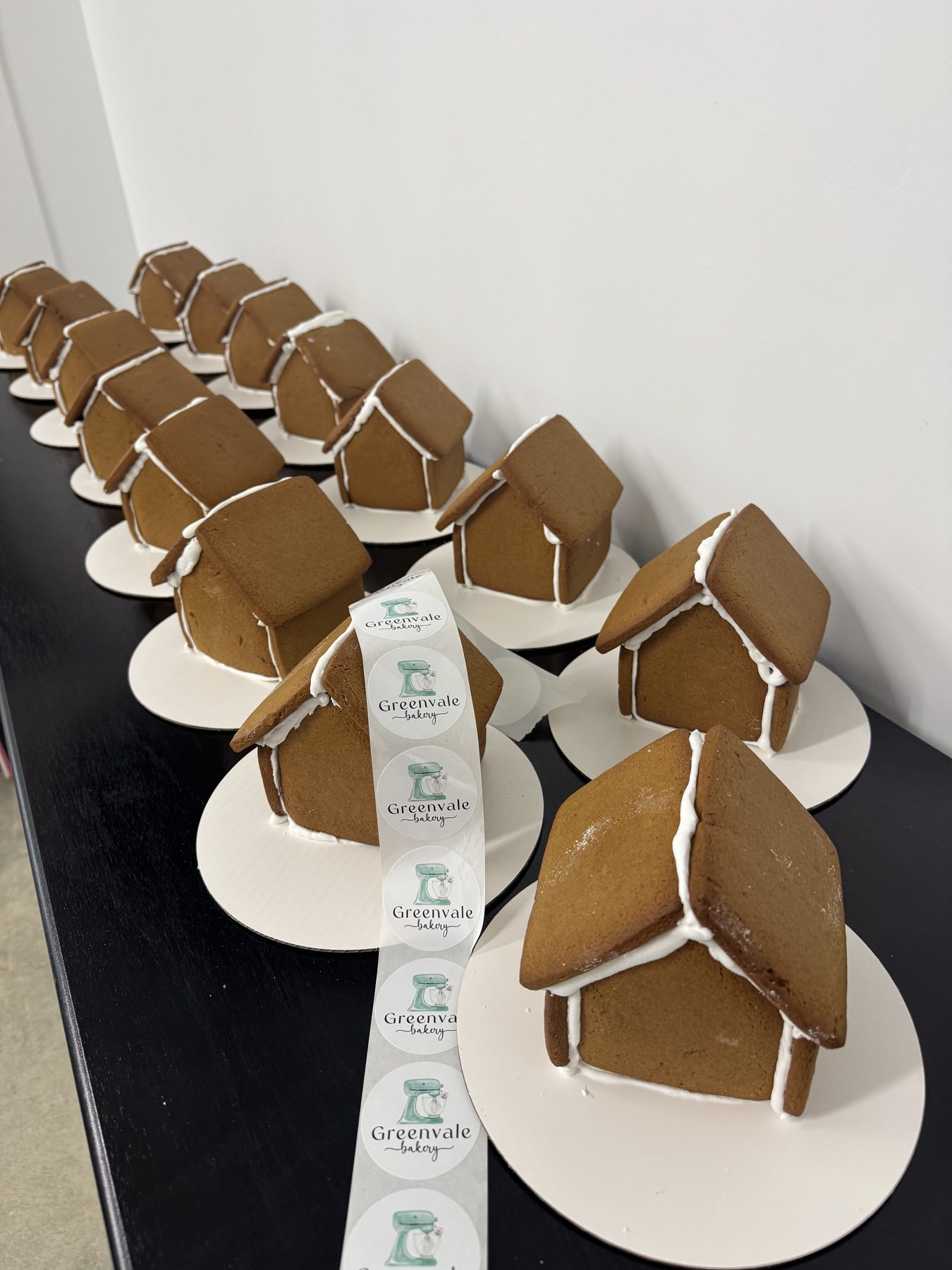 Rows of individually plated gingerbread houses prepared for an event